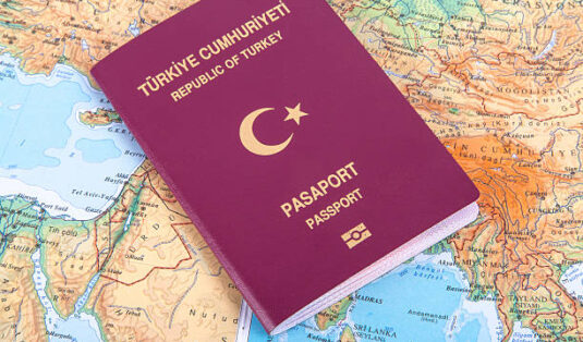 Close up detailed view of a Turkish passport lying on a world map.